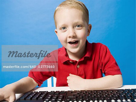Junge, sitzen an der Tastatur lächelnd