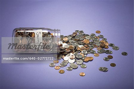 Glas mit Münzen und Einsparungen Etikett und verstreuten