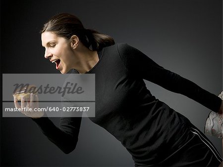 Woman holding a donut and stretching