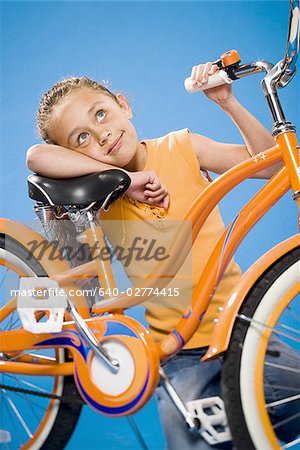 Girl on orange bicycle smiling