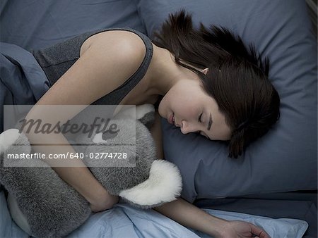 Woman sleeping in bed with stuffed animal