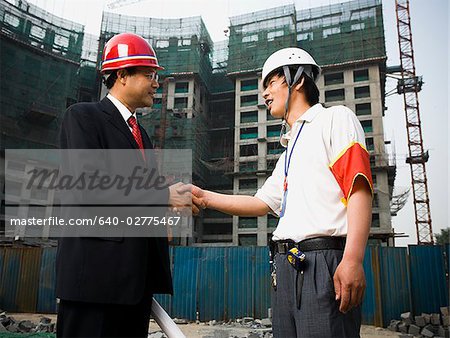 Extérieur contremaître et travailleur de construction lui serrer la main