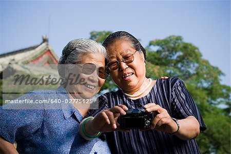 Two women embracing outdoors with camera