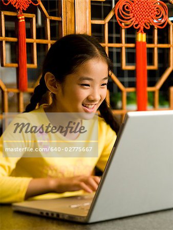 Fille assise avec ordinateur portable souriant