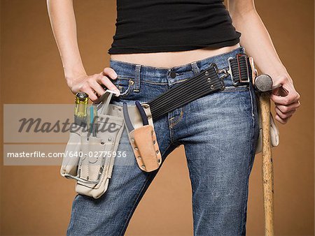 Mid section view of woman with tool belt