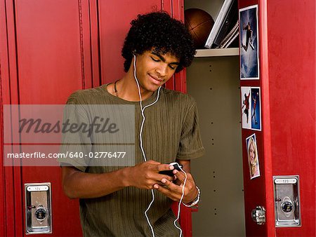 Lycée garçon à l'école à l'écoute de lecteur MP3.