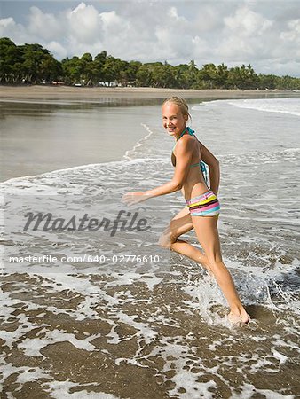 Young girl running in the surf.