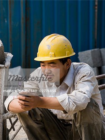 Construction worker looking at his cell phone.