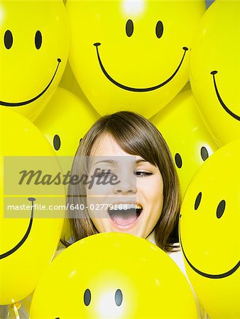 femme avec des ballons de visage de smiley