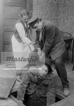 TWO MEN PULLING COWBOY UP FORM UNDERNEATH TRAPDOOR IN FLOOR