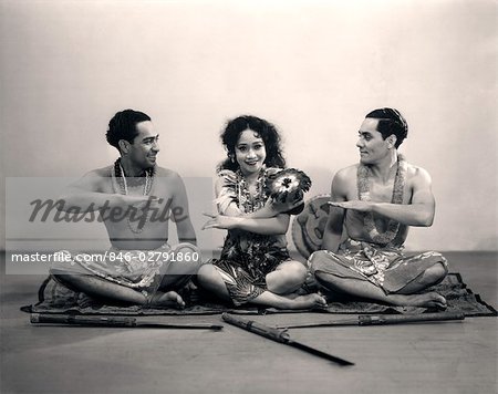 1920s WOMAN & TWO MEN SITTING ON FLOOR DOING POLYNESIAN DANCE WITH HAND GESTURES