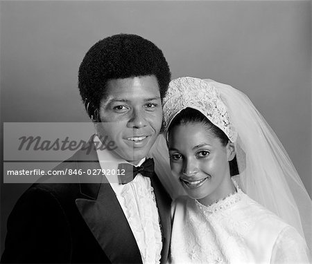 1970s SMILING AFRO-AMERICAN PORTRAIT BRIDE & GROOM WITH ARMS AROUND EACH OTHER LOOKING AT CAMERA