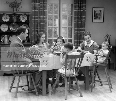 1930ER JAHRE FAMILIE VON 6 SITZEN AM TISCH IM SPEISESAAL ESSEN FRÜHSTÜCK DAS BABY SITZT IN EINEN HOCHSTUHL