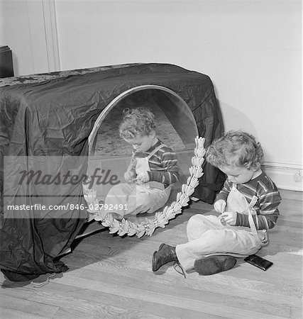 1950s SMALL BOY SITTING ON FLOOR BEFORE MIRROR PLAYING WITH TRINKET