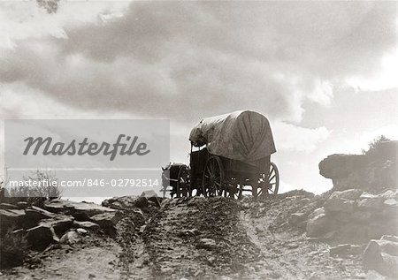 CONESTOGA WAGON ON DIRT ROAD ON CREST OF HILL