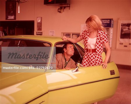 1960s COUPLE IN AUTOMOBILE SHOWROOM