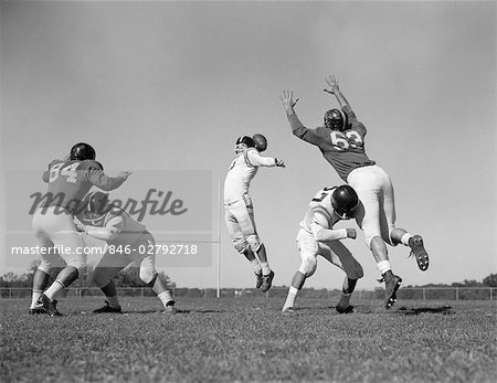 1960ER JAHREN FÜNF MÄNNER FUßBALL ZWEI SPIELER GEGNER BLOCKIEREN, WÄHREND QUARTERBACK WIRFT BALL SPIELEN