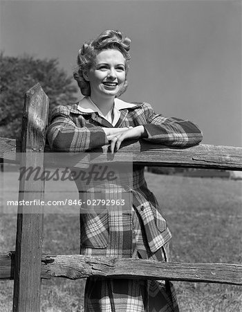 1940ER JAHRE BLONDE FRAU LÄCHELND PORTRAIT SCHIEFEN WAFFEN AUF HOLZZAUN TRAGEN PLAID TARTAN ANZUG MODE