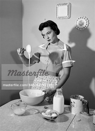 1960s HOUSEWIFE MIXING STICKY BATTER IN KITCHEN
