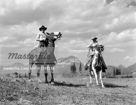 1930s PAIR OF COWBOYS ON HORSEBACK AT GLACIER FIFTY-MILE CAMP