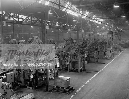 1960s FACTORY INTERIOR WITH MULTIPLE DIE PRESSES MAKING ROUND ENDS FOR CANS