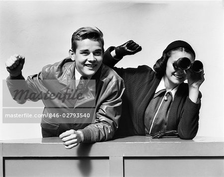 1940s TEENAGE COUPLE BOY GIRL WATCHING RACE WITH BINOCULARS EXCITED CHEERING