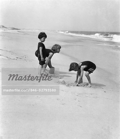 1920s 3 KIDS BOYS GIRLS BOY DIGGING SAND GIRL EMPTYING SAND PAIL BUCKET PLAY PLAYING SUMMER FUN NEW JERSEY SHORE