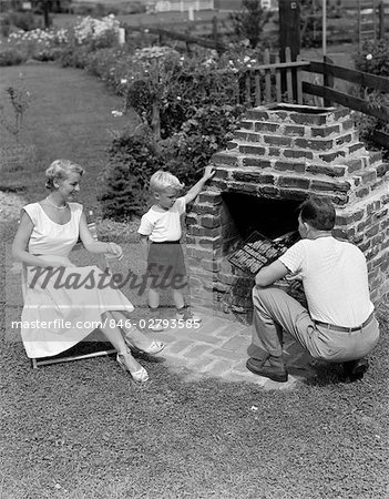 1940s 1950s FAMILY IN BACKYARD COOKING HAMBURGERS ON BRICK BARBEQUE