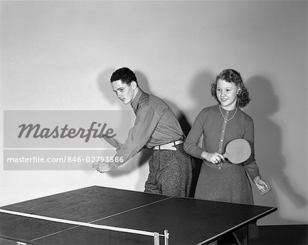 1940s YOUNG TEEN COUPLE BOY GIRL ON SAME SIDE TABLE PLAYING PING PONG AS TEAM