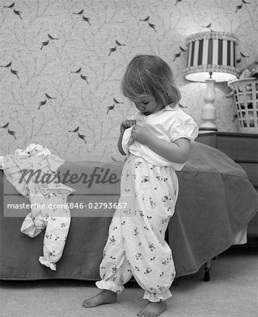 1960ER JAHRE BEDTIME WENIG BLOND GIRL IN PYJAMA BÖDEN UNBUTTONING SHIRT, PUT ON PYJAMA TOP