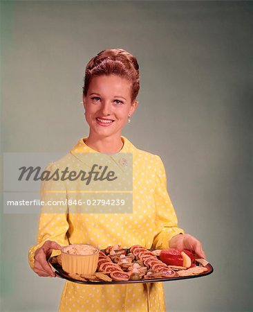 1960s WOMAN HOLDING A TRAY OF PARTY SNACK FOOD SMILING STUDIO INDOOR