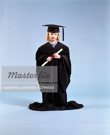 1980s LITTLE GIRL WEARING GRADUATION CAP AND GOWN HOLDING DIPLOMA