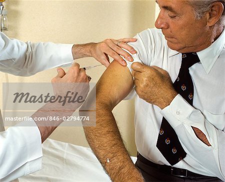1970s DOCTOR GIVING INJECTION TO SENIOR MAN