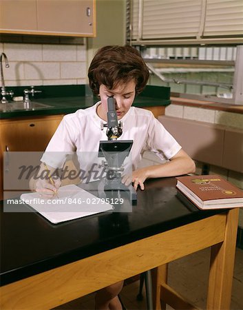 1960s FEMALE TEEN STUDENT COED AT MICROSCOPE TAKING NOTES BIOLOGY TEXTBOOK HIGH SCHOOL