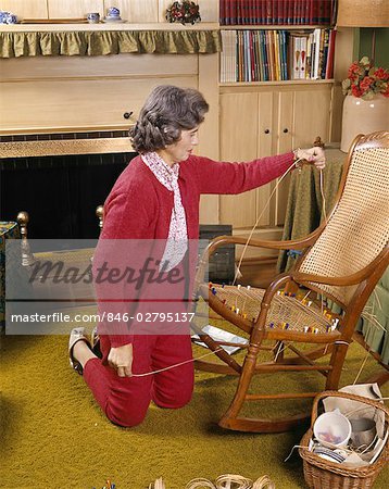 1960s MIDDLE AGED WOMAN REPAIRING CANED CHAIR SEAT