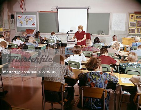 ENSEIGNANT DES ANNÉES 1960 AVEC CLASSE EN SALLE DE CLASSE AVEC ÉQUIPEMENT AUDIOVISUEL MACHINE