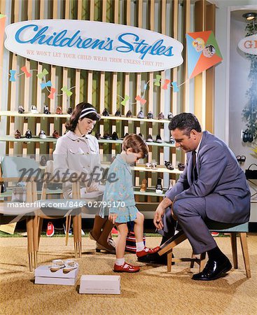 1960s 1970s MOTHER WATCHING SALESMAN FIT SHOES ON DAUGHTER IN SHOE SECTION OF DEPARTMENT STORE
