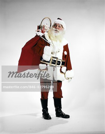 1960s FULL LENGTH PORTRAIT OF SANTA CLAUS WITH STUFFED TOY SACK ON HIS BACK STUDIO