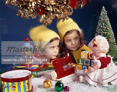 1960s TWIN SISTERS LOOKING AT TOY DISPLAY IN STORE WINDOW NOSTALGIA TWO GIRL SEASON
