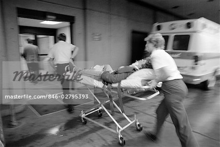1980s EMT TEAM RUSHING PATIENT INTO HOSPITAL ON STRETCHER