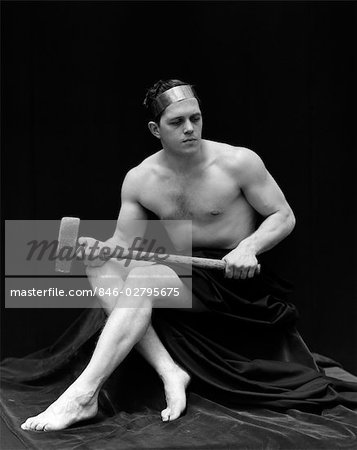 1920s MAN SEMI NUDE HOLDING LONG ARMED HAMMER ACROSS LEGS WEARING HEAD BAND RETRO VINTAGE