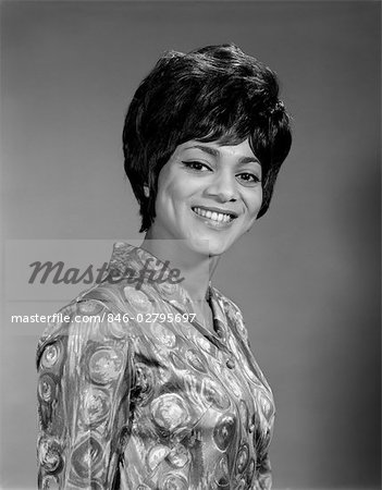 AFRICAN AMERICAN NEGRO BLACK WOMAN 3 4 POSE TOWARD CAMERA SMILE SHORT HAIR TEETH BLOUSE LOUD BUSY DESIGN 1960s