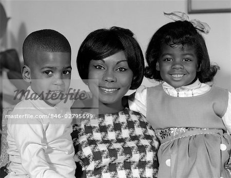 1960s PORTRAIT OF AFRO-AMERICAN MOTHER WITH ARMS AROUND SON & DAUGHTER