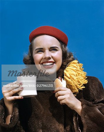 1940s 1950a SMILING COLLEGE GIRL WEARING FUR COAT HOMECOMING MUM HOLDING CUP AND HOT DOG