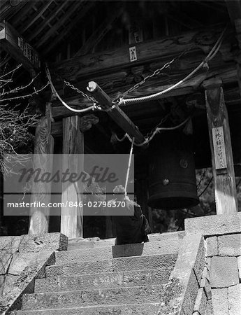 1930s RELIGION JAPANESE MAN PRIEST PULLING BACK LOG TO RING HUGE BRONZE BELL RINNOJI TEMPLE NIKKO JAPAN