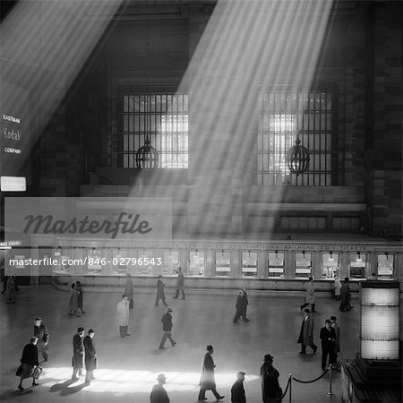 1960s CROWD WALKING PAST THE SUNBEAMS COMING THROUGH THE MAGNIFICENT DRAMATIC POETIC CAVERNOUS ATRIUM OF GRAND CENTRAL STATION NEW YORK CITY USA