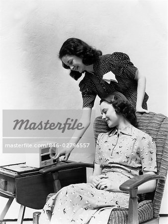 1930s 1940s TWO WOMEN SMILING LISTENING TO RADIO