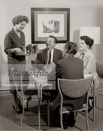 1950s CARD PARTY OF 2 COUPLES WITH WOMAN SERVING DRINKS