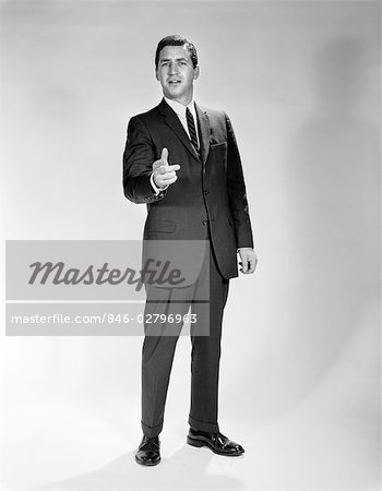 1960s MAN FULL LENGTH PORTRAIT POINTING GESTURE WEARING SUIT BUSINESSMAN SPOKESPERSON