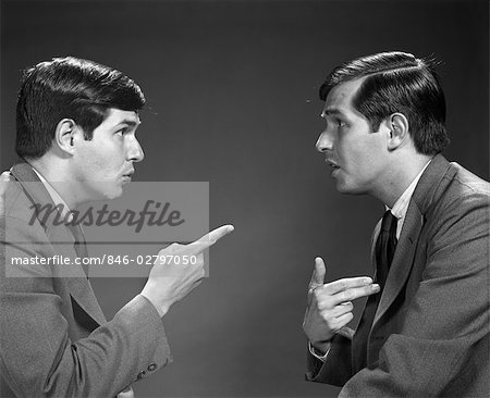 1960s MAN DOUBLE EXPOSURE TALKING TO HIMSELF POINTING